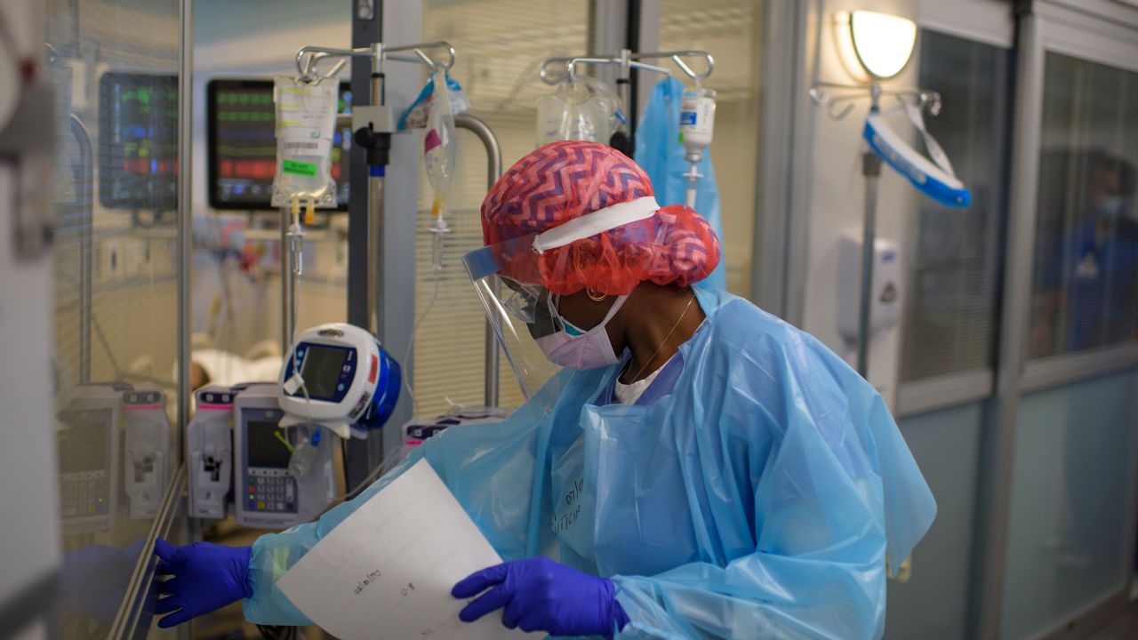 Registered Respiratory Therapist Niticia Mpanga walks into a Covid patients room in the ICU at Oakbend Medical Center in Richmond, Texas, on July 15, 2020. -The latest modeling projects the number of COVID-19 deaths in the US to increase further, even as one research team suggests the near-universal use of masks could save 40,000 lives between now and November (Photo by Mark Felix/AFP/Getty Images)