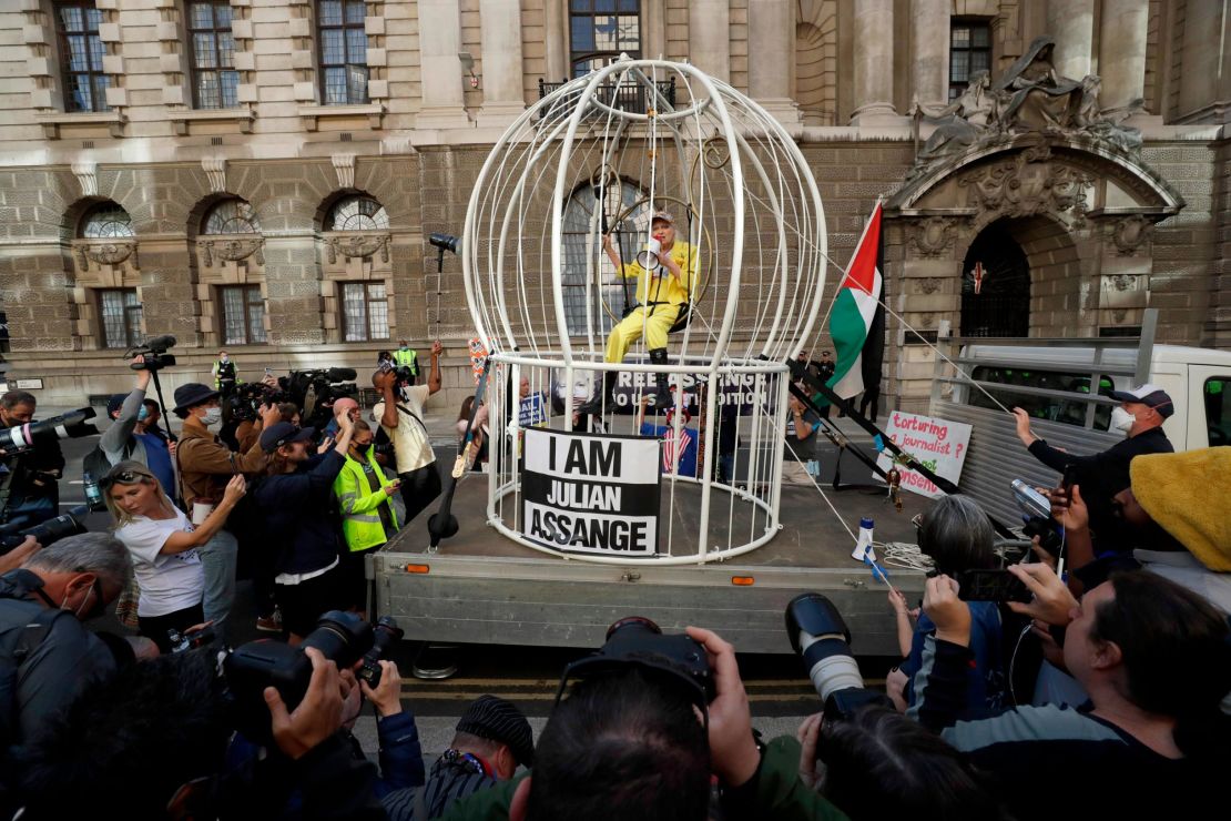 Vivienne Westwood sits suspended in a giant bird cage outside the Old Bailey court in London on July 21.