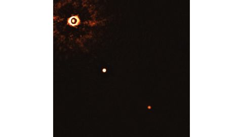 This image shows a young sun-like star being orbited by two gas giant exoplanets. It was taken by the SPHERE instrument on European Southern Observatory's Very Large Telescope. The star can be seen in the top left corner, and the planets are the two bright dots.