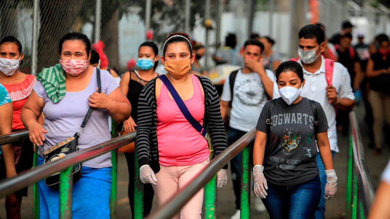 Workers wear masks as protection against the spread of coronavirus as they leave after a day's work in Managua, Nicaragua, on May 11, 2020. 