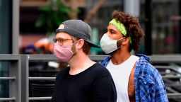 Young men wearing facemasks due to the coronavirus pandemic are seen in Los Angeles on June 29, 2020 where the largest single-day number of new COVID-19 cases in the county since the pandemic began was confirmed, with a spike among the younger population. - The coronavirus pandemic is "not even close to being over", the WHO warned today, as the global death toll passed half a million and cases surge in Latin America and the United States.