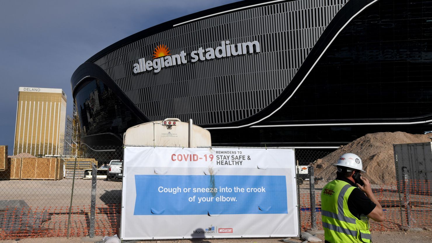 A sign with guidelines for how to stay safe from the coronavirus is posted on a fence at Allegiant Stadium, the future home of the Las Vegas Raiders, in Las Vegas, Nevada.