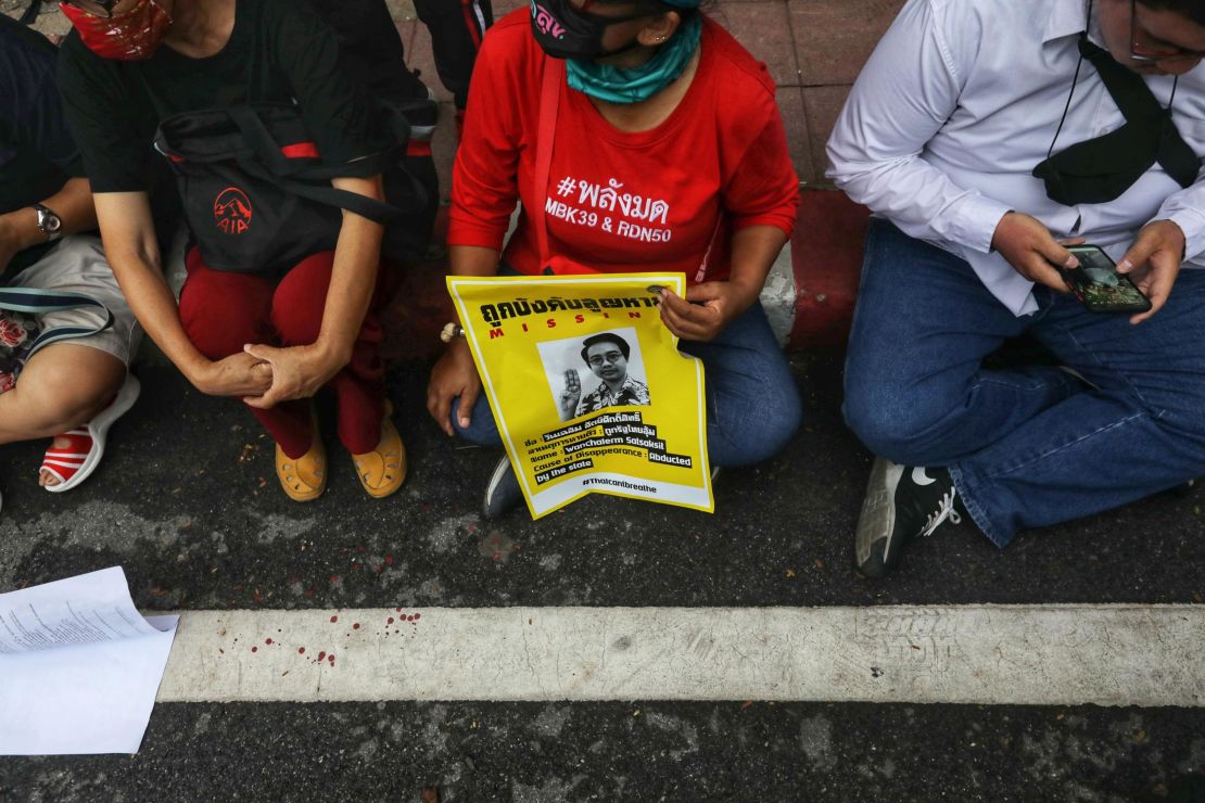 A woman holds a poster featuring missing pro-democracy activist Wanchalearm Satsksit during a demonstration in front of the army headquarters in Bangkok on July 20, 2020. 