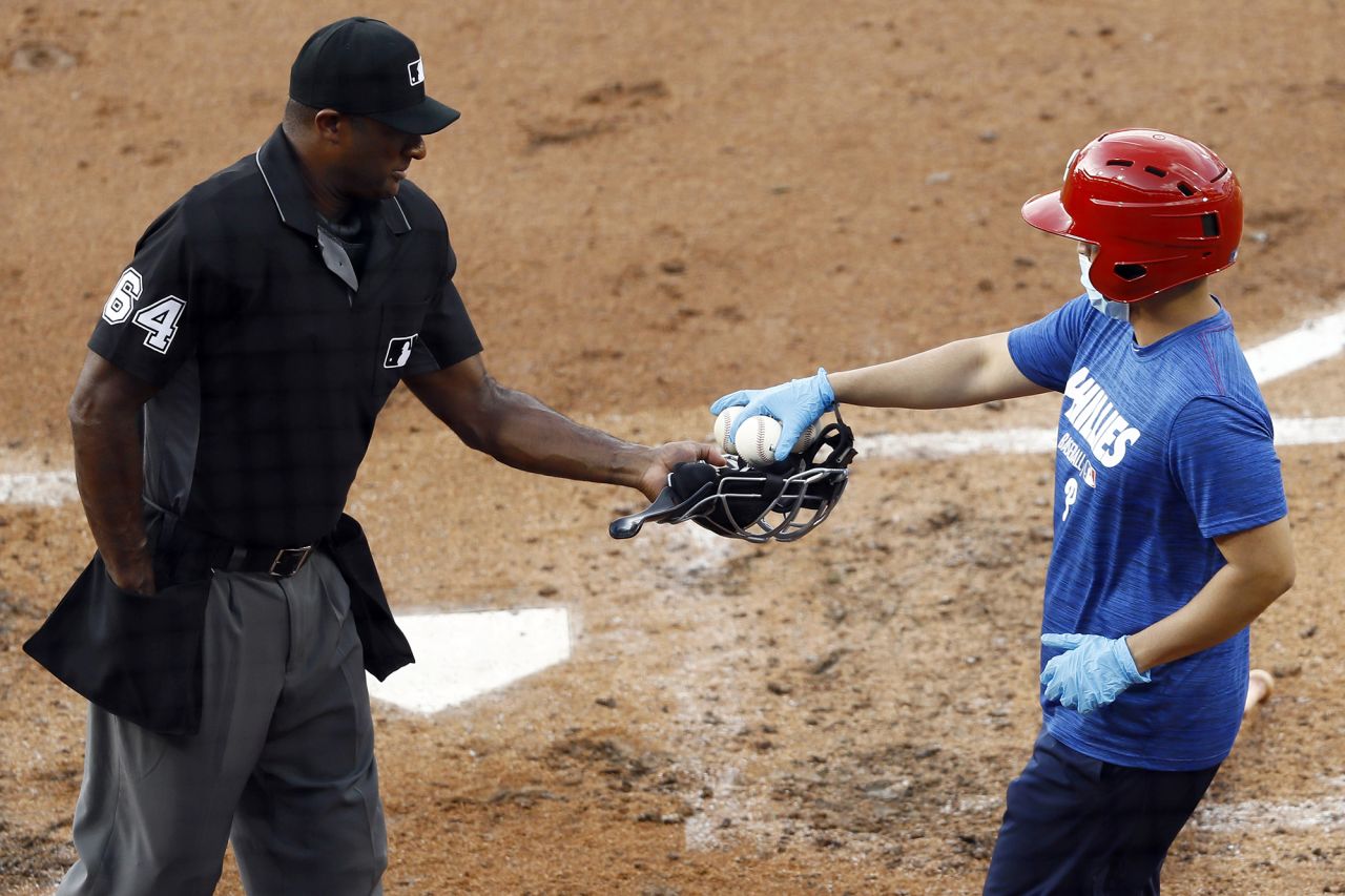 Umpire Alan Porter receives baseballs from a Philadelphia Phillies bat boy during a team scrimmage on July 14.