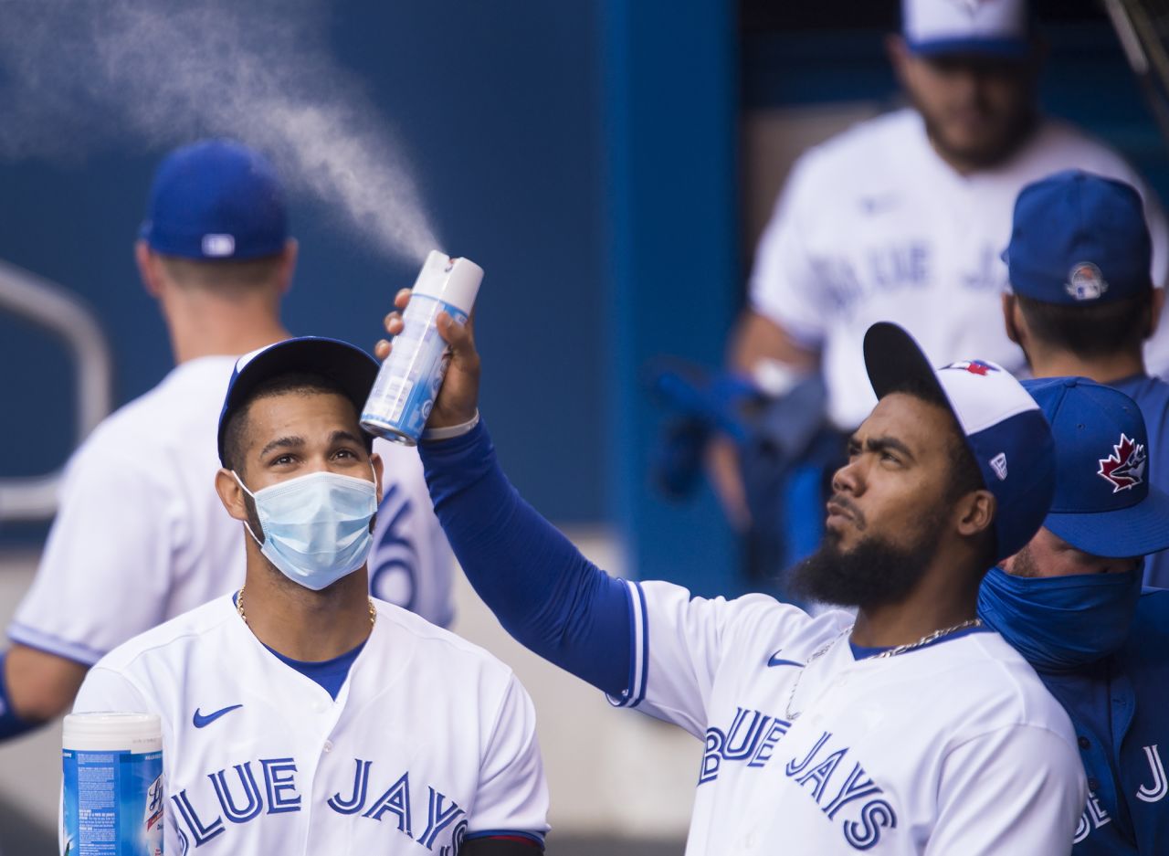Toronto's Teoscar Hernandez sprays sanitizer in the dugout during an intrasquad game on July 17.