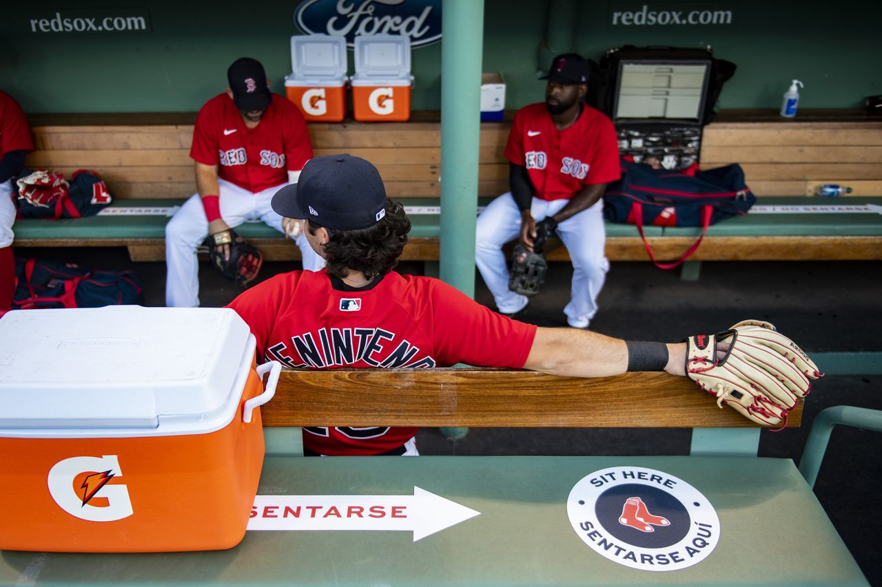 Members of the Boston Red Sox sit apart from one another in a Fenway Park dugout before scrimmaging Toronto on Tuesday, July 21.