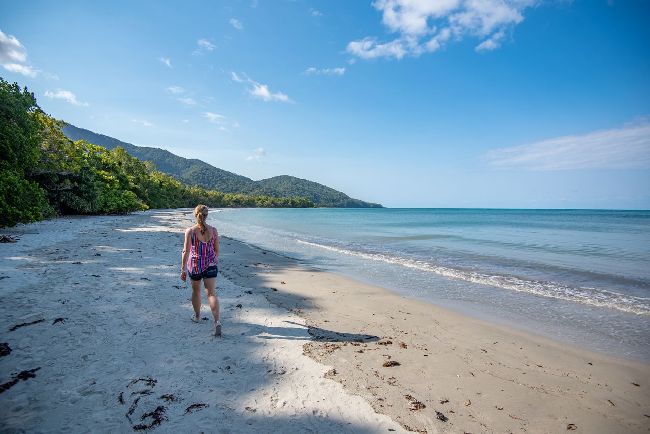 Take a solo walk along a deserted beach in Queensland, Australia.