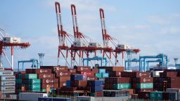 Containers sit next to gantry cranes at a shipping terminal in Yokohama, Japan, on Sunday, July 19, 2020. Japanese exports fell by more than 20% for a third straight month even as key markets started to reopen from virus shutdowns.