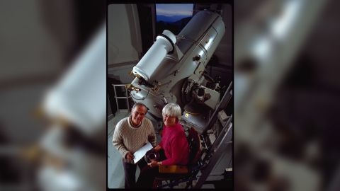 Carolyn and Eugene Shoemaker stand by the 18" Schmidt Telescope at the Palomar Observatory. They used it to search for asteroids and comets that may come close to the earth's orbit. 