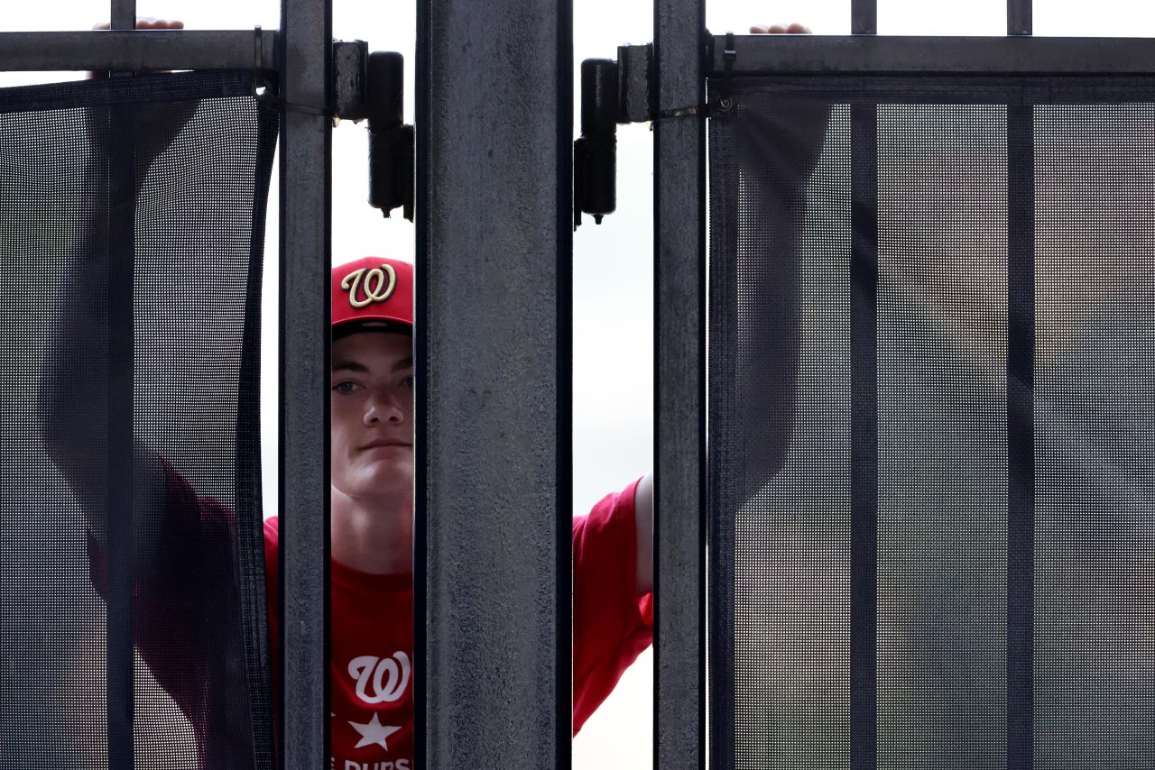A Nationals fan looks through a stadium gate on Thursday.