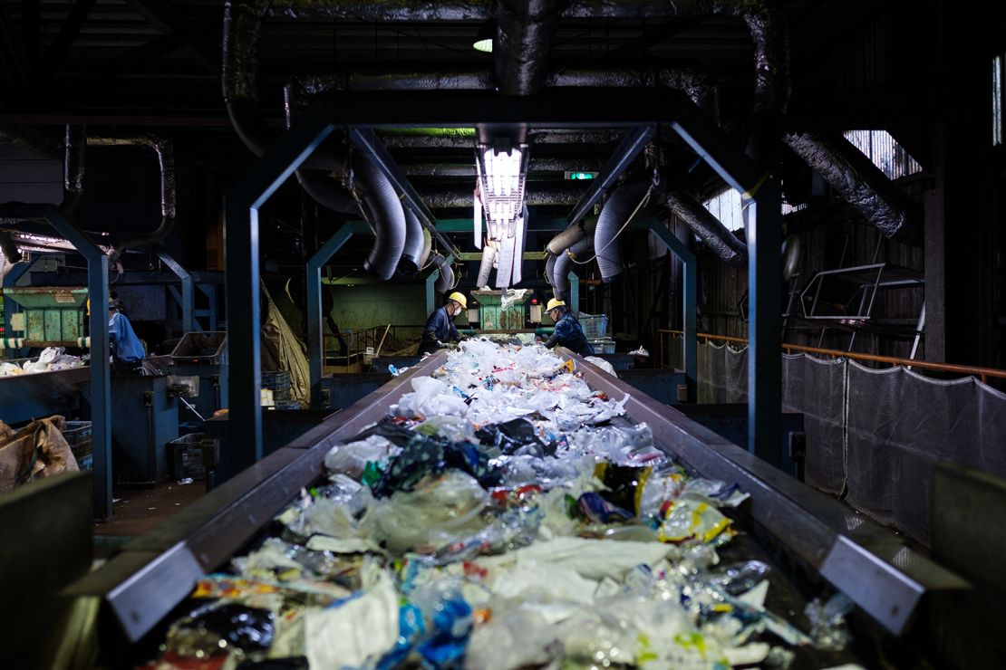 Workers sort disposable plastic waste on a conveyor at Ichikawa Kankyo Engineering recycle center. Tokyo's Katsushika city office brings some 10 tons of plastic recyclable resources to the recycling facility daily.