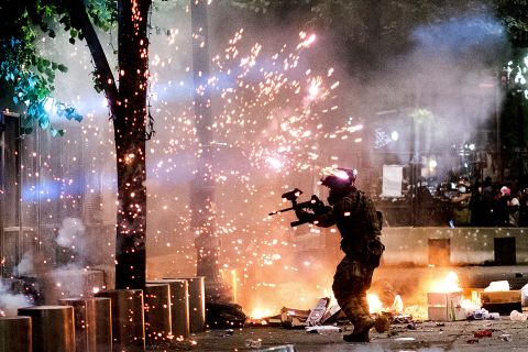 A federal officer fires crowd-control munitions at demonstrators on July 24.