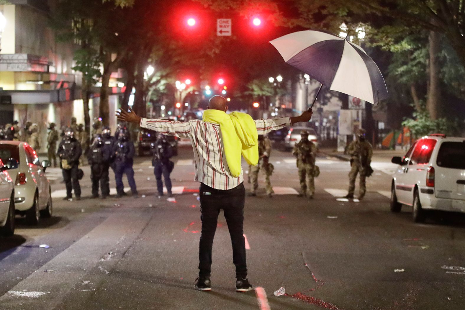 A demonstrator stands in front of agents outside the federal courthouse on July 24.