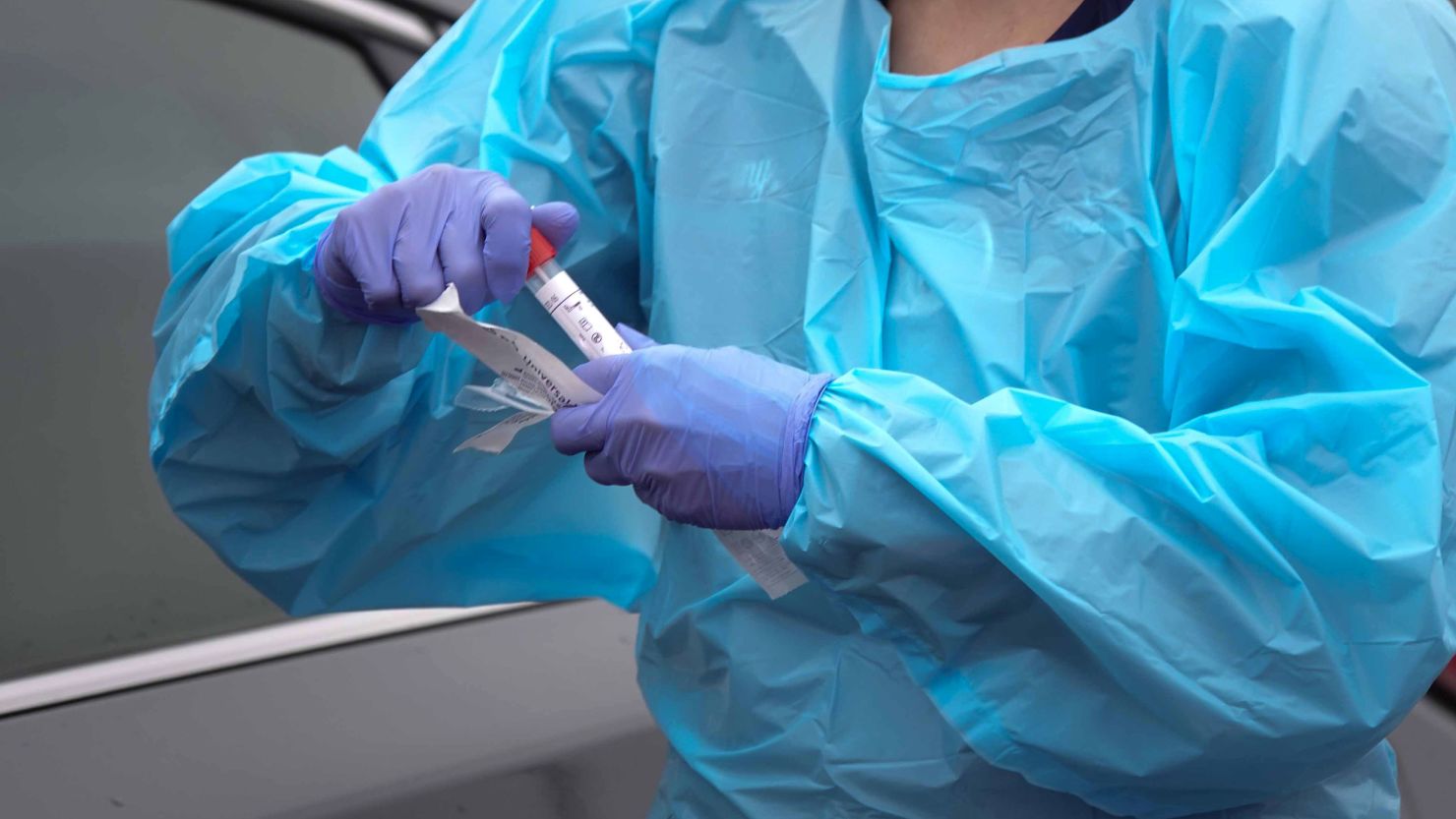 In Wilmington, Delaware, a health care worker holds a tube with a fresh swab from a person visiting a free coronavirus testing site in a drive-thru in the parking lot of Chase Center.