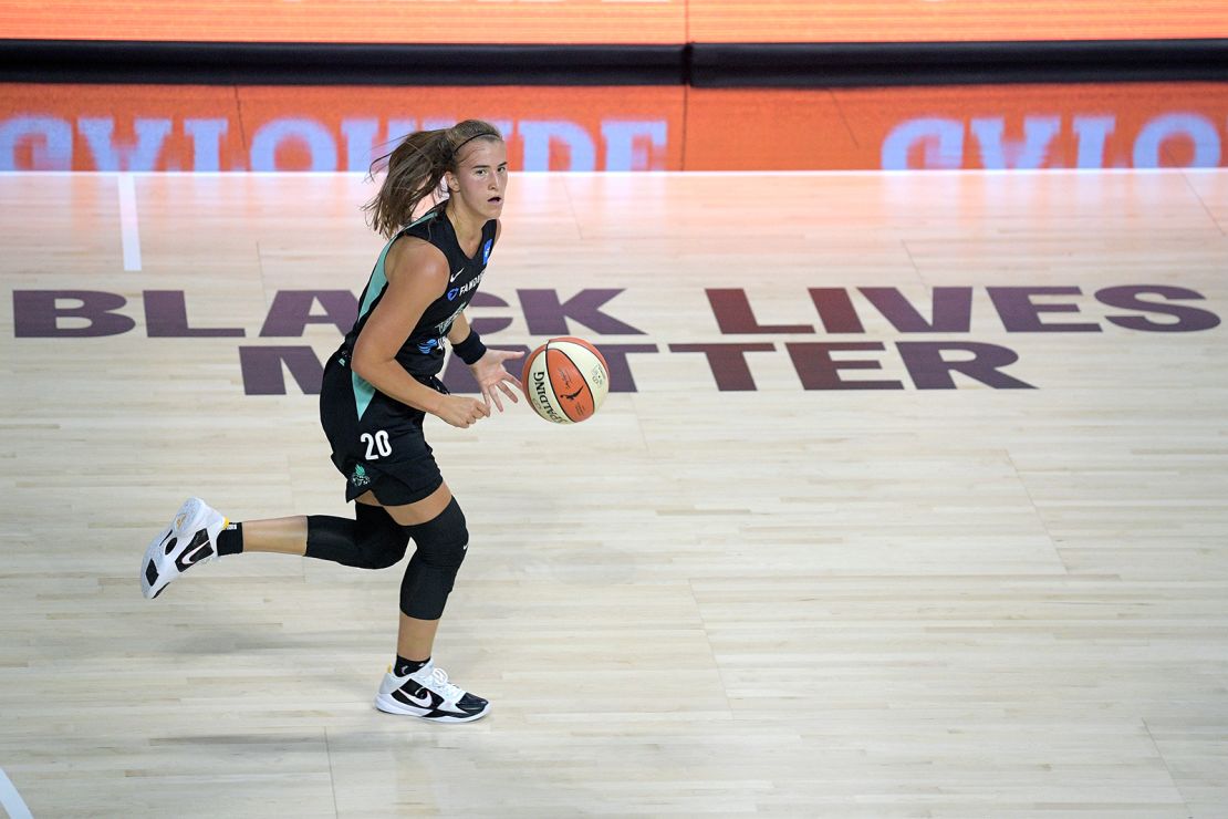 New York Liberty forward Sabrina Ionescu (20) pushes the ball up the court during the first half against the Seattle Storm, with the BLM printed in the background.