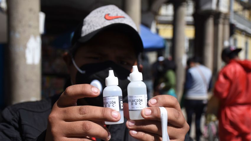 A man shows bottles of chlorine dioxide he purchased at a pharmacy in Cochabamba, Bolivia, Friday, July 17, 2020. Long lines form every morning in Cochabamba, one of the Bolivian cities hardest hit by the new coronavirus pandemic, as people wait to buy small bottles of chlorine dioxide, a toxic bleaching agent that has been falsely touted as a cure for COVID-19 and myriad other diseases. (AP Photo/Dico Solis)