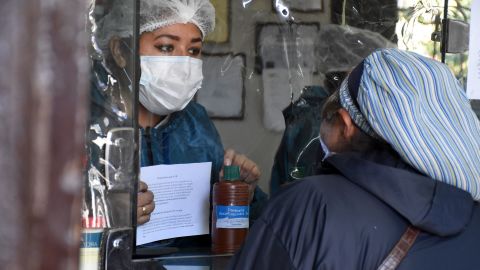A woman buys chlorine dioxide at a pharmacy in Cochabamba on July 17, 2020.