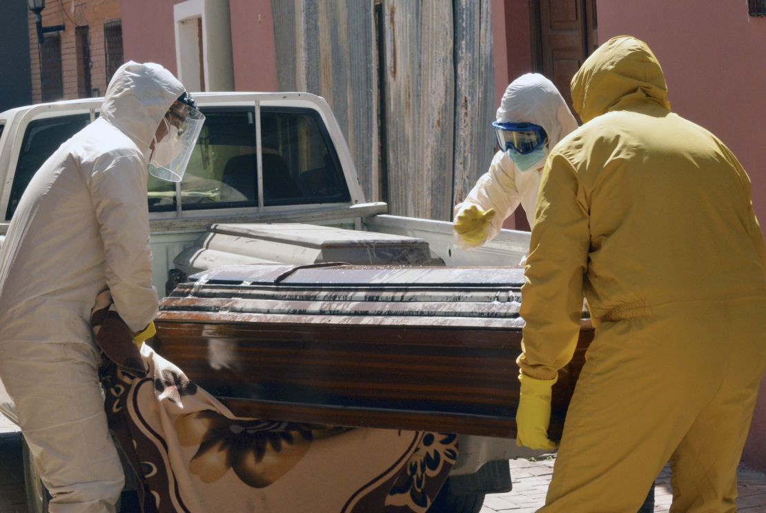 Medical workers carry a coffin containing a coronavirus victim in Cochabamba.