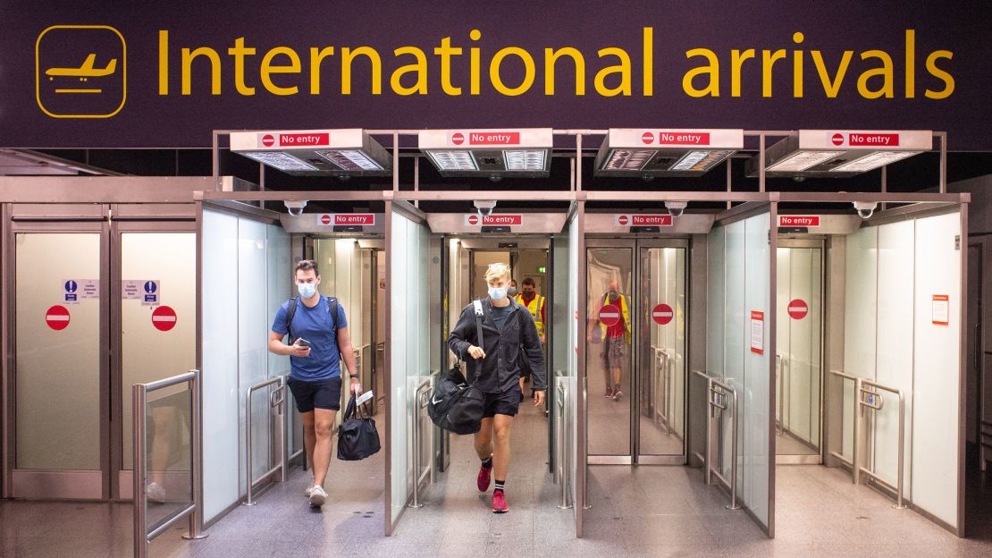 Travelers arrive at Gatwick Airport, England, following the news that holidaymakers returning from Spain will need to self-isolate for 14 days.