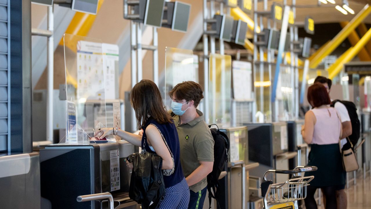 Passengers wearing face masks at Adolfo Suarez-Barajas international airport in Madrid, where coverings have become mandatory in all public places.