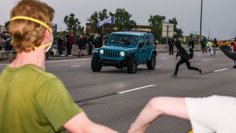 People run to get out of the way as a Jeep speeds through a crowd of people protesting the death of Elijah McClain on I-225 on July 25, 2020, in Aurora, Colorado.