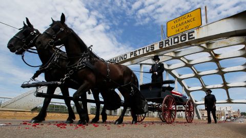 The casket of Rep. John Lewis moves over the Edmund Pettus Bridge by horse drawn carriage during a memorial service for Lewis on Sunday in Selma, Alabama.