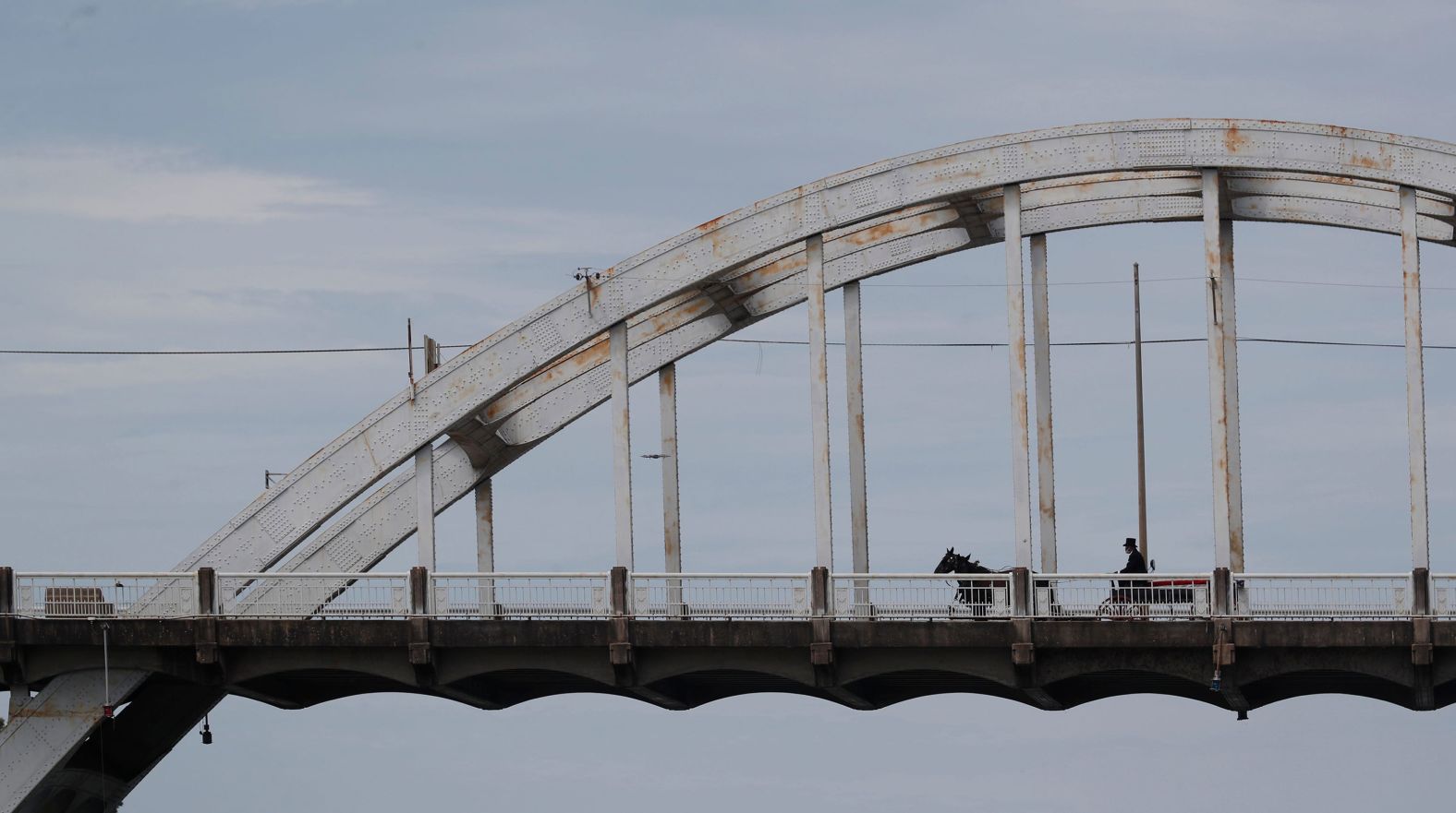 The horse-drawn carriage moves across the Edmund Pettus Bridge.