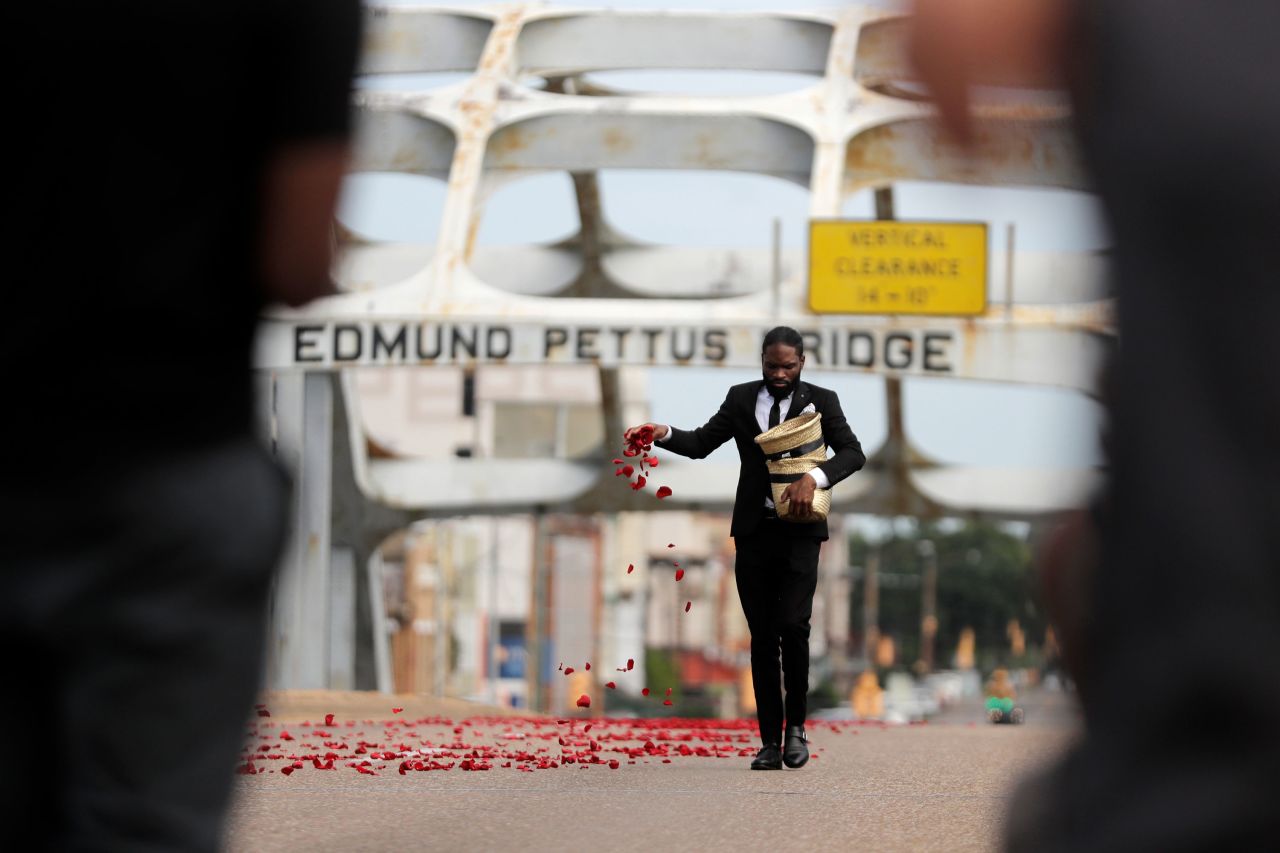A man places flower petals on the Edmund Pettus Bridge before Lewis' casket was pulled across.