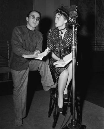 De Havilland wears a polka-dot frock in this image of the actress alongside director Arch Oboler, as part of the recording of radio play "Johnny Quinn, U.S.N." (1942).