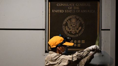 A worker attempts to remove a plaque on the wall outside the US Consulate in Chengdu, southwestern China.