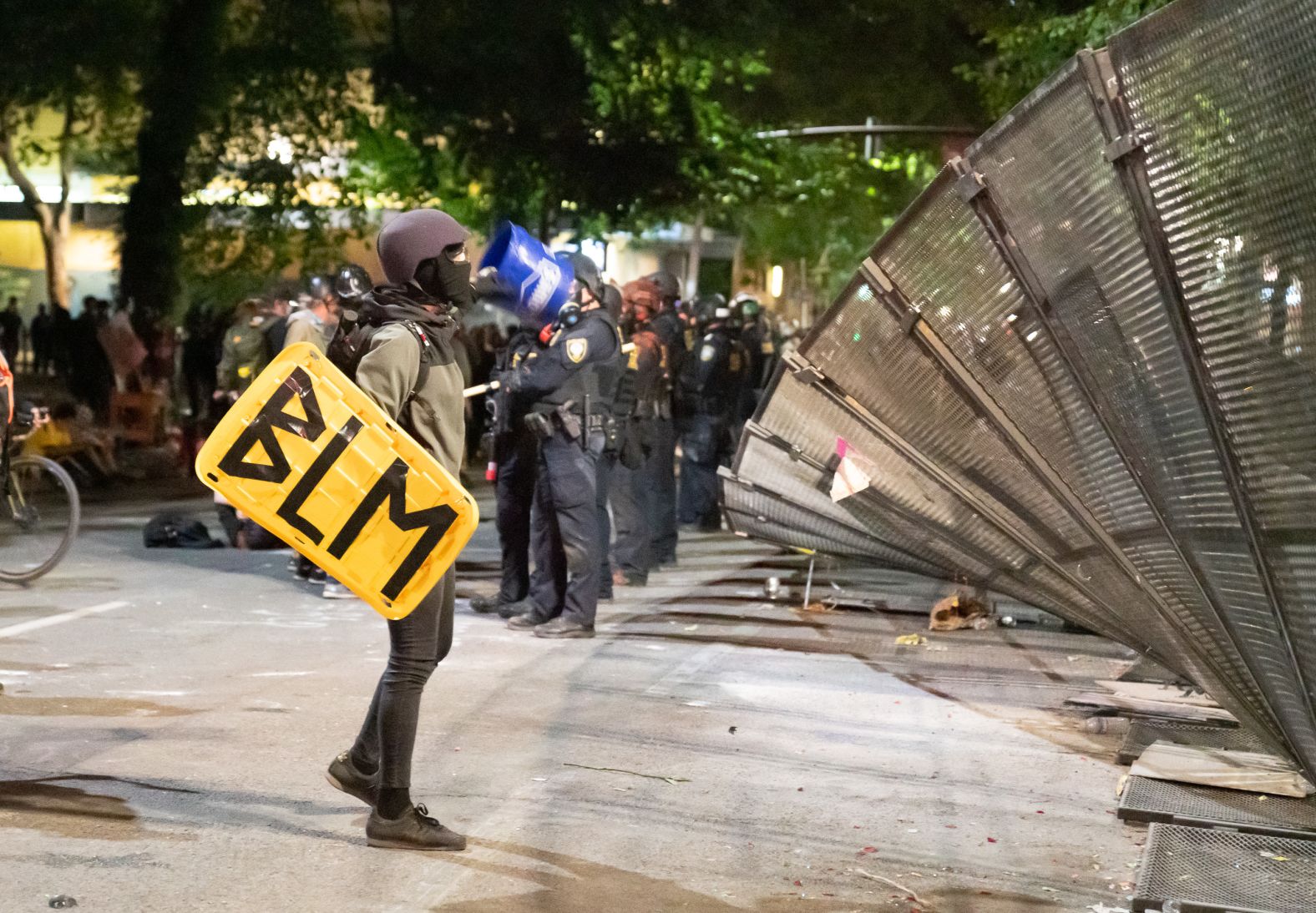 A protester inspects a torn-down fence outside the federal courthouse on July 26.