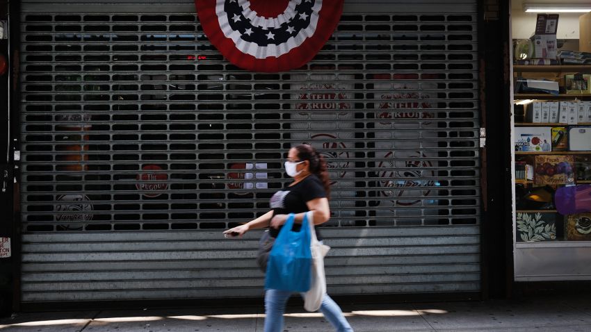 People walk by stores, many closed,  along River Avenue near Yankee Stadium on July 23, 2020 in the Bronx borough of New York City. Yankee stadium, which is closed to fans due to COVID-19 and social distancing restrictions, was a magnet for traffic to businesses in the area surrounding the famed stadium and many now stand closed or operate on restricted hours. The area of the South Bronx adjacent to the stadium has an unemployment rate of over 21 percent and is one of the country's poorest congressional districts. Major League Baseball will start up tonight to stadiums empty of fans.  (Photo by Spencer Platt/Getty Images)