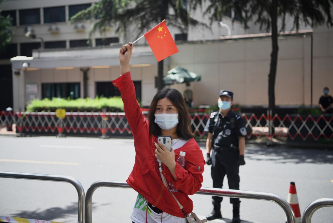 A woman waves a Chinese flag in front of the US consulate in Chengdu, southwestern China.