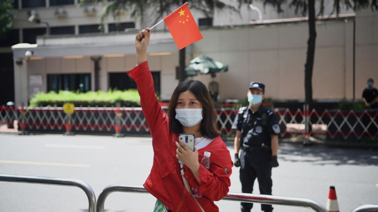 A woman waves a Chinese flag in front of the US consulate in Chengdu, southwestern China.