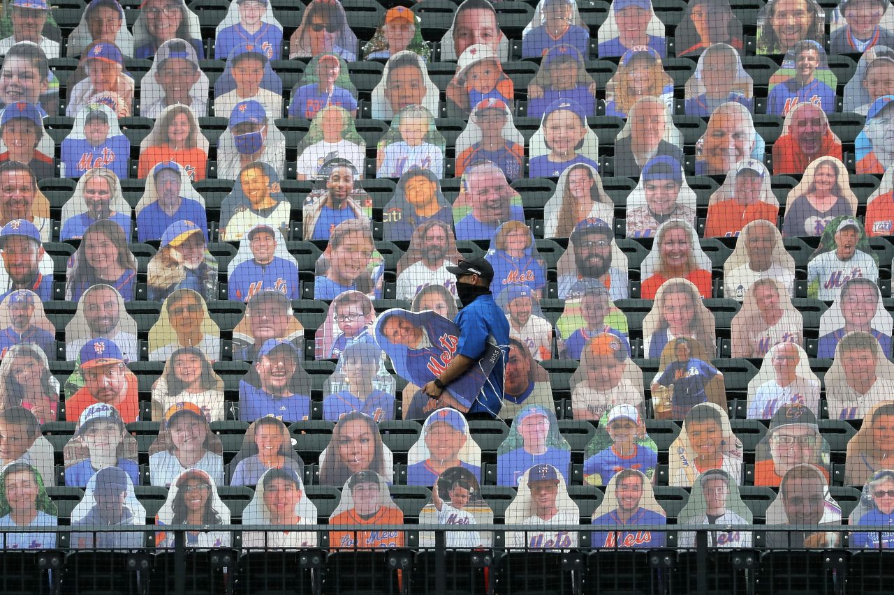 A New York Mets employee places fan cutouts before the team's opener on Friday, July 24.