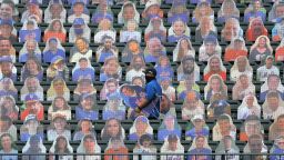 New York Mets employees place cutouts of fans in the seats before the team's Opening Day game Friday in New York.