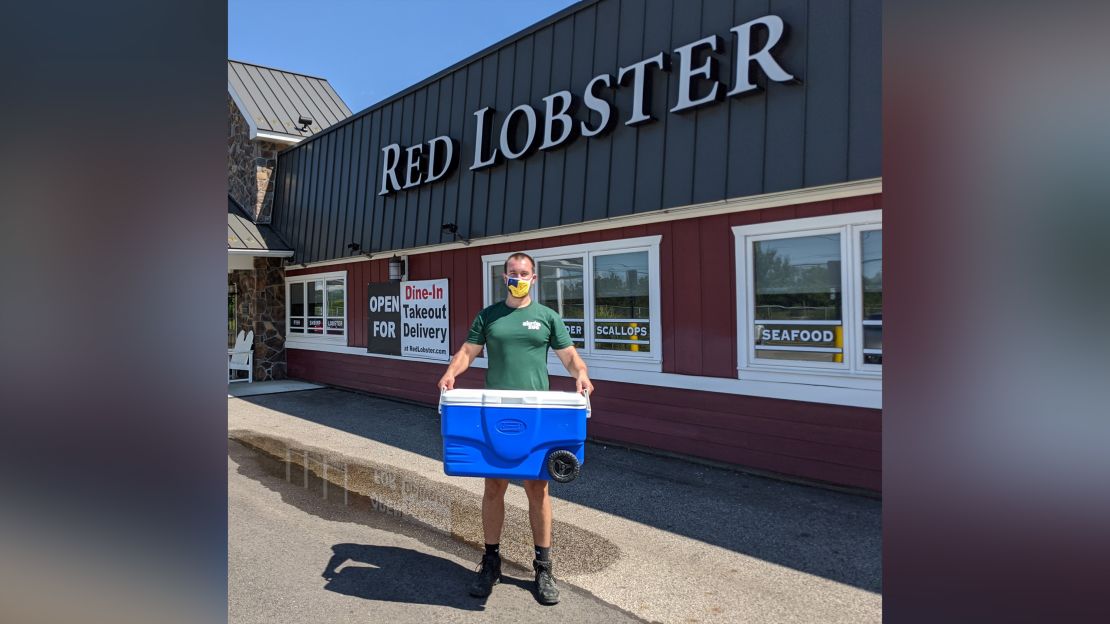 An Akron Zoo staff member picks up the lobster from the Red Lobster restaurant.