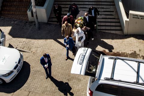 The casket of a coronavirus victim is carried from a funeral home in Johannesburg on July 26.