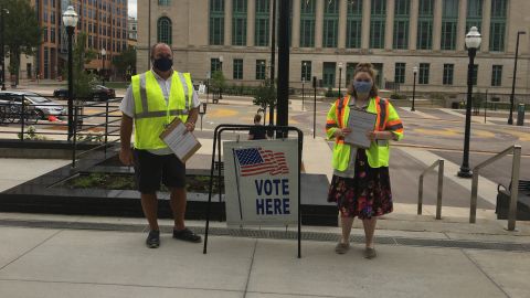 Isabel Behl, 18, and Chief Inspector Blaise Besant work on drive-up absentee voting in Madison, Wisconsin, on July 28.