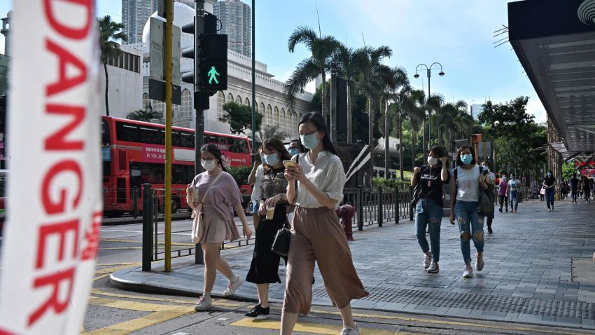 Pedestrians wearing face masks walk across a road in Hong Kong on July 27, 2020. - Everyone in Hong Kong will have to wear masks in public from this week, authorities said on July 27, as they unveiled the city's toughest social distancing measures yet to combat a new wave of COVID-19 coronavirus infections. (Photo by Anthony WALLACE / AFP) (Photo by ANTHONY WALLACE/AFP via Getty Images)