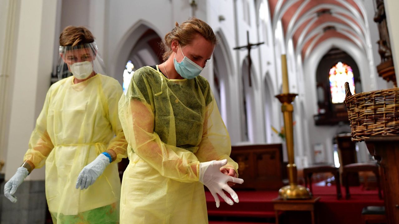 Nurses put on protective gear and gloves before taking a nasal swab test for the novel coronavirus at a temporary testing center at a church in Antwerp, Belgium, on Monday.