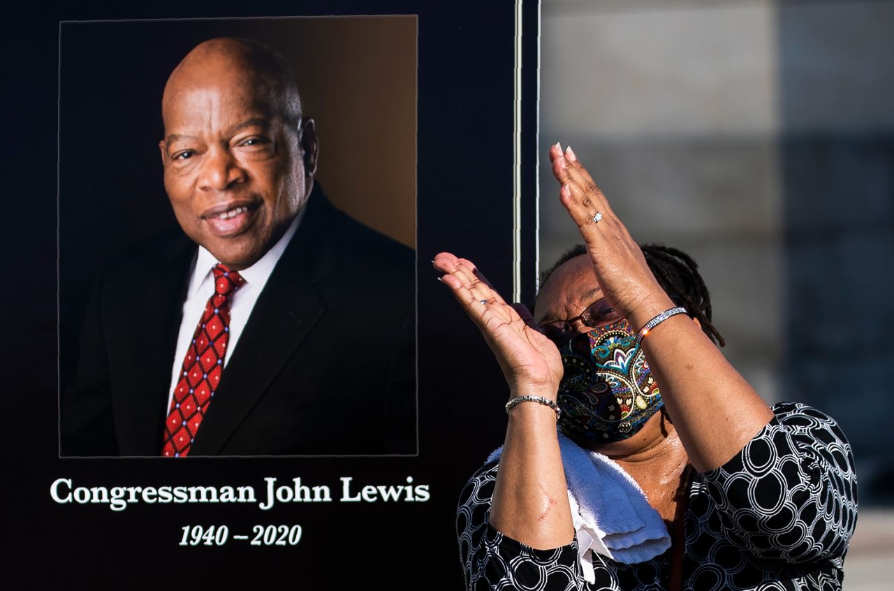 Jaquenette Ferguson of Oxon Hill, Maryland, gets her picture taken beside a Lewis portrait near the Capitol steps.