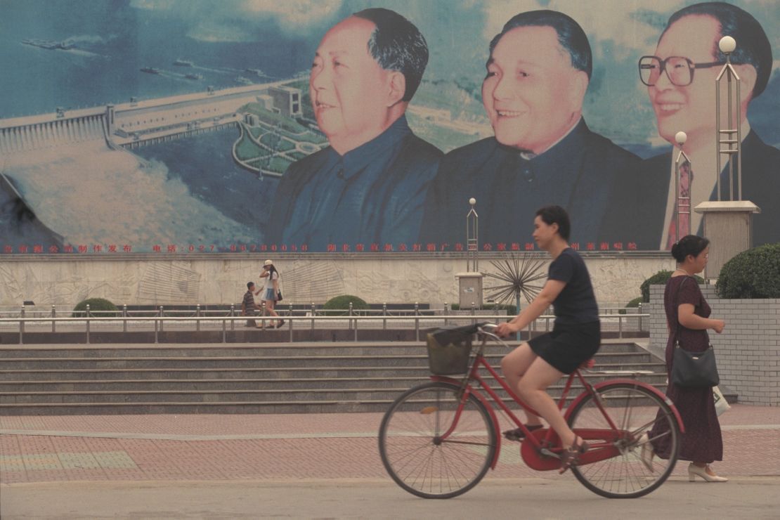The faces of Chinese leaders Mao Zedong, Deng Xiaoping and Jiang Zemin appear on a large mural of the Three Gorges Dam in Wuhan.