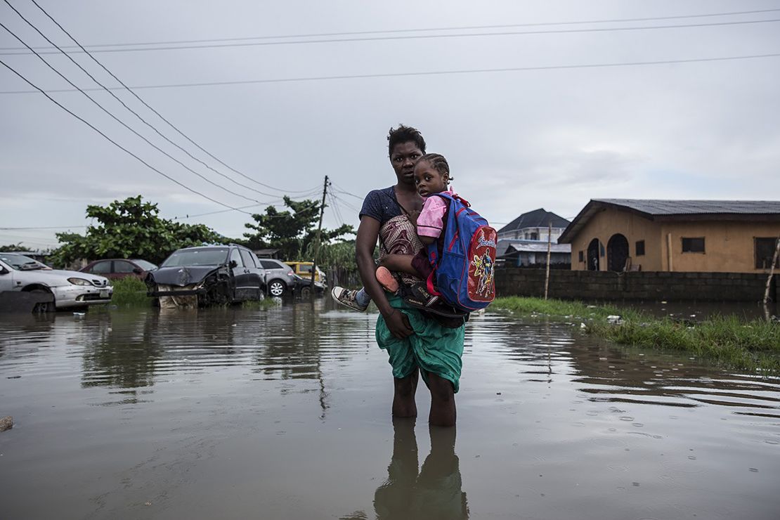 Going Under
Lagos, Nigeria, 2019
A mother carries her children to school through a flooded street.
