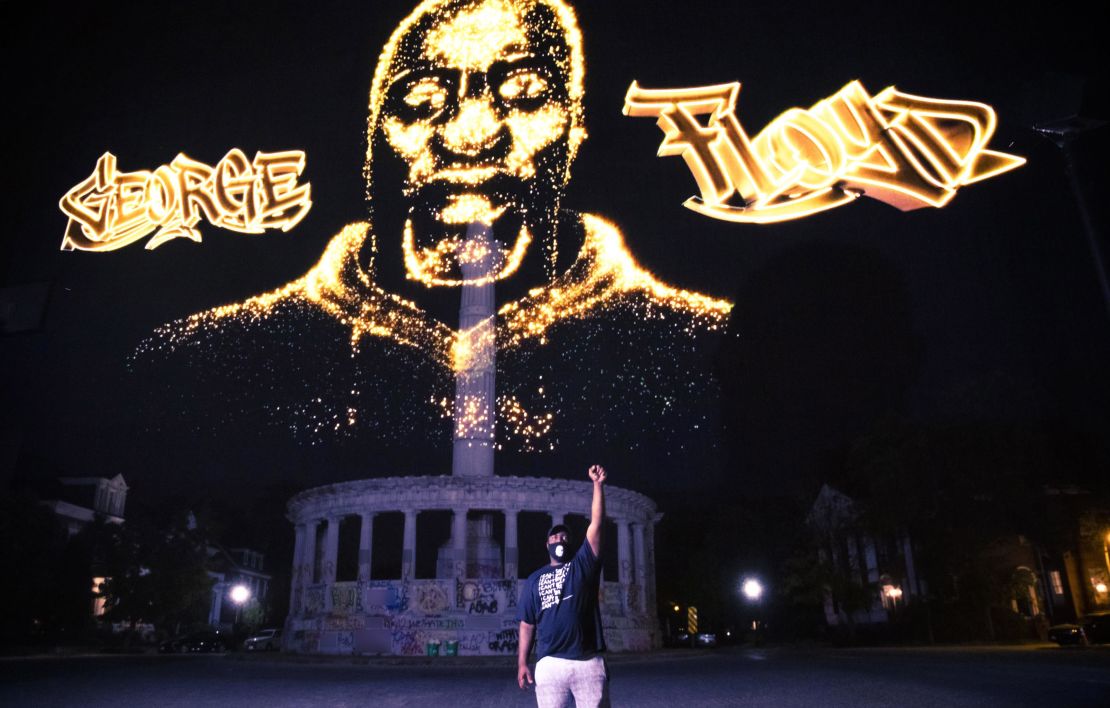 Rodney Floyd stands in front of a hologram honoring his brother as it is projected over the Robert E. Lee statue in Richmond, Virginia. CNN obscured portions graffiti on the statue that contained profanity. 