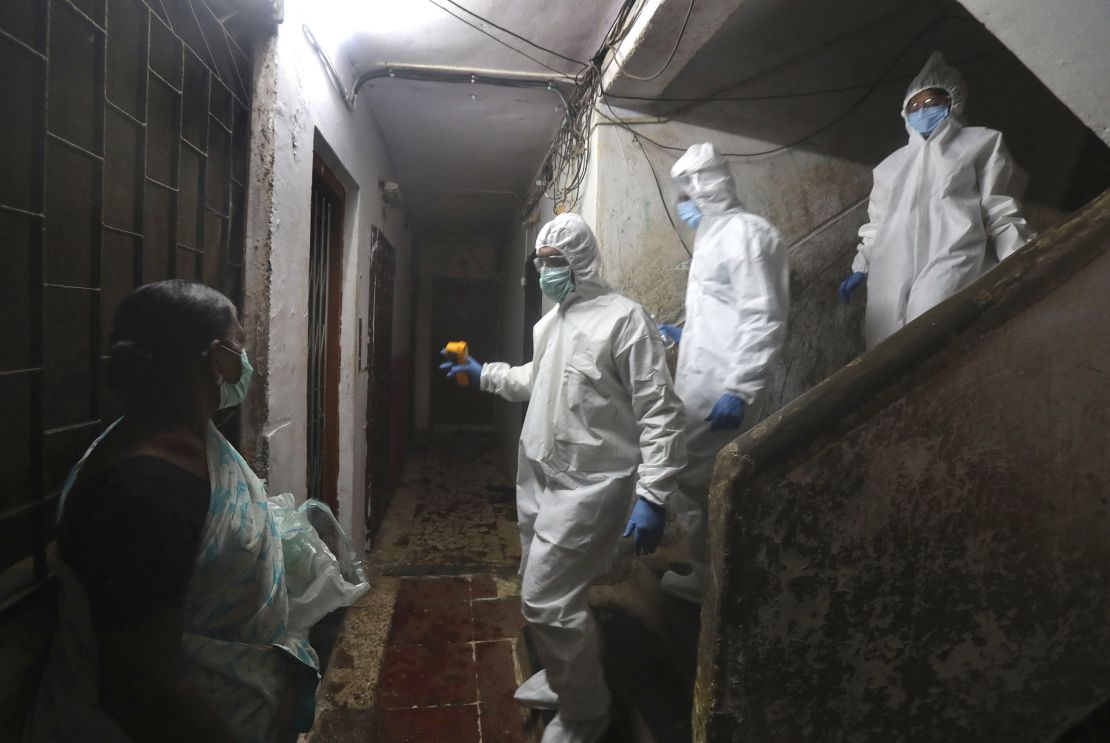 Health workers screen people for Covid-19 symptoms at a residential building in Dharavi, one of Asia's biggest slums, in Mumbai, India, Friday, July 17, 2020. 