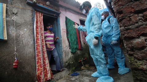 A healthcare worker wearing checks the temperature of a resident during a medical check-up at a slum in Mumbai, India on July 20, 2020. 