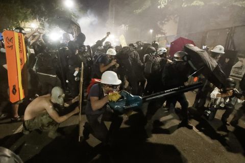 Protesters blow back tear gas with leaf blowers on July 29.