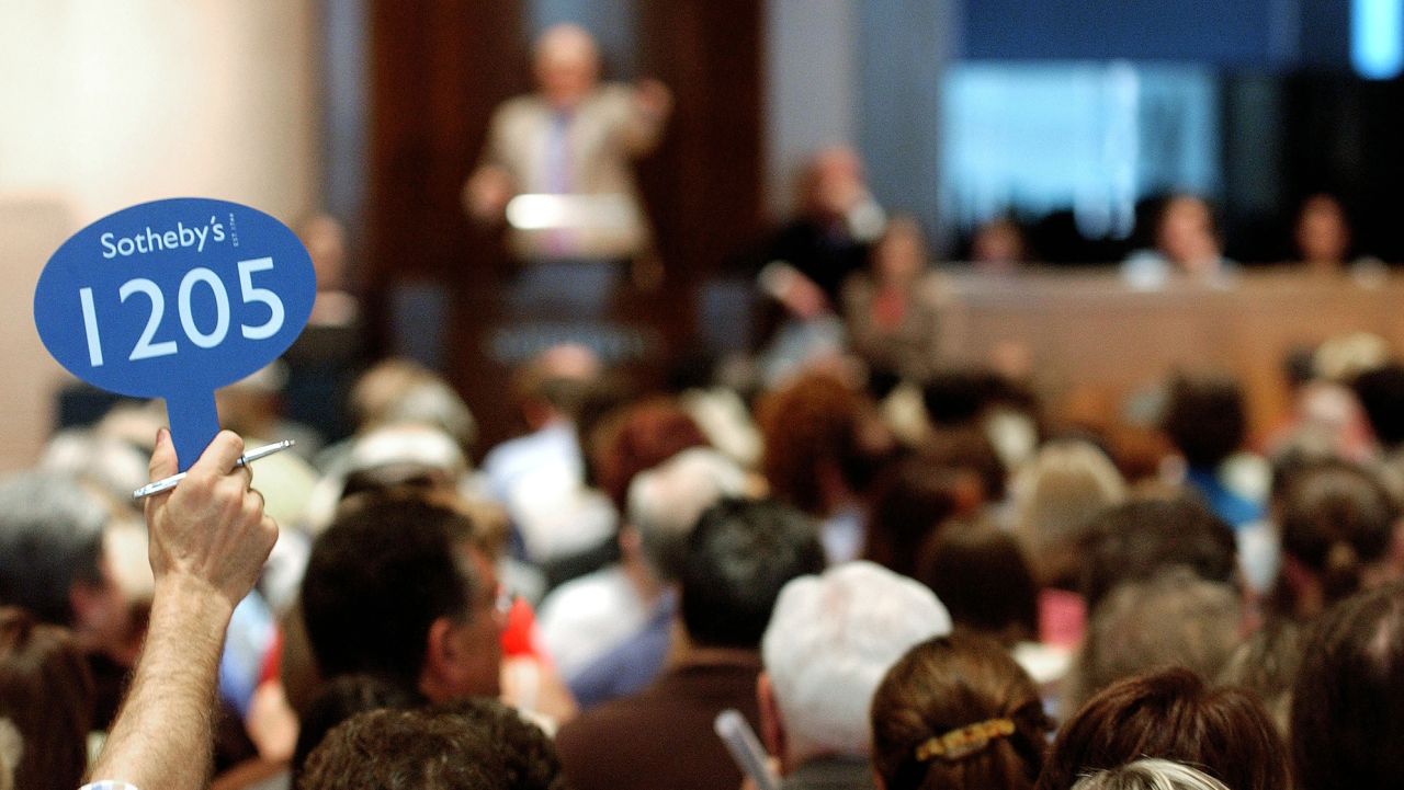 A bidder holds up his bidding sign during an auction at Sotheby's in June 2004 in New York City. (Photo by Stephen Chernin/Getty Images)