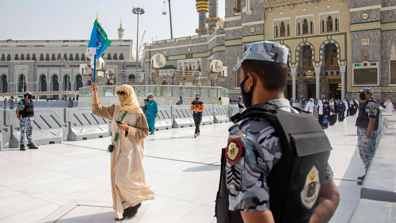 Security personnel standby as pilgrims arrive keeping social distancing to limit exposure and the potential transmission of the coronavirus.